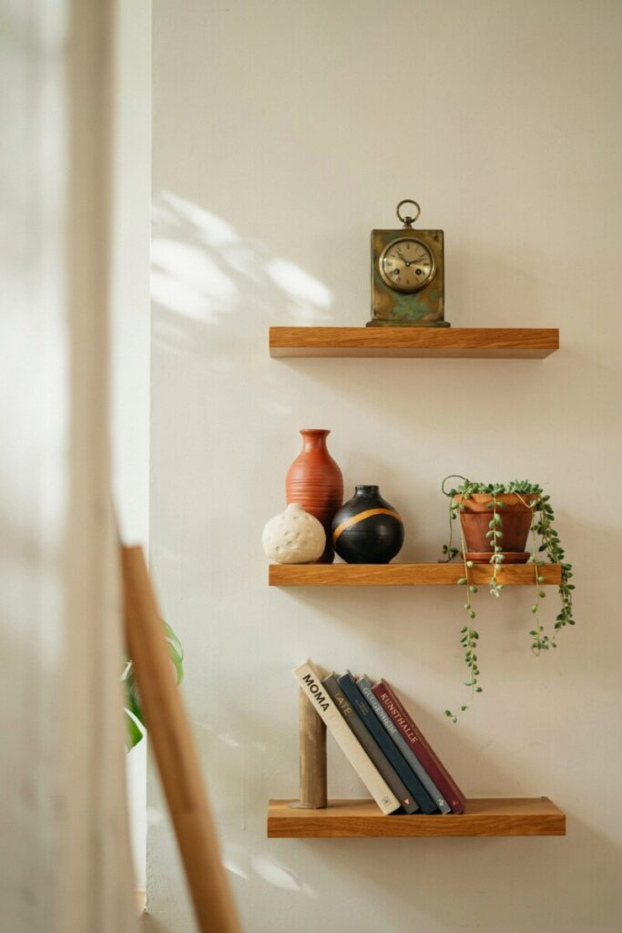 A staggered shelf styled with sculptural vases from a trip to Oaxaca, a stack of art monographs,
