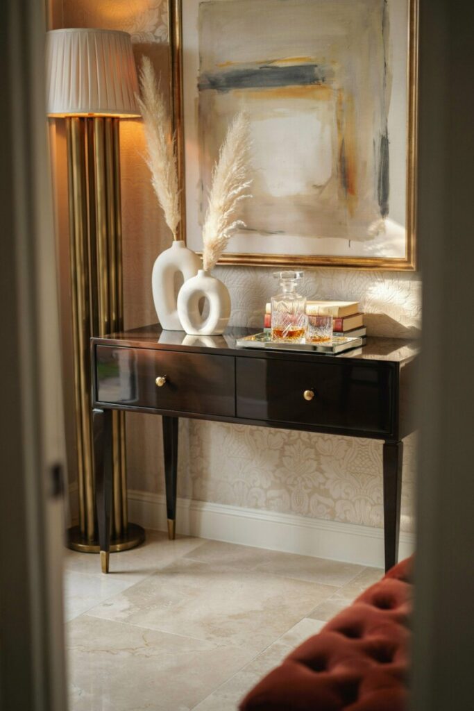 Black lacquer console table showing high-shine finishes in Hollywood Regency decor.
