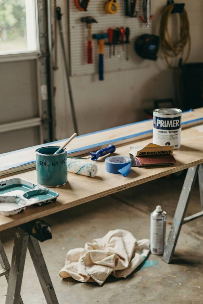 DIY painted accent shelf mid-project with paint cans and brushes