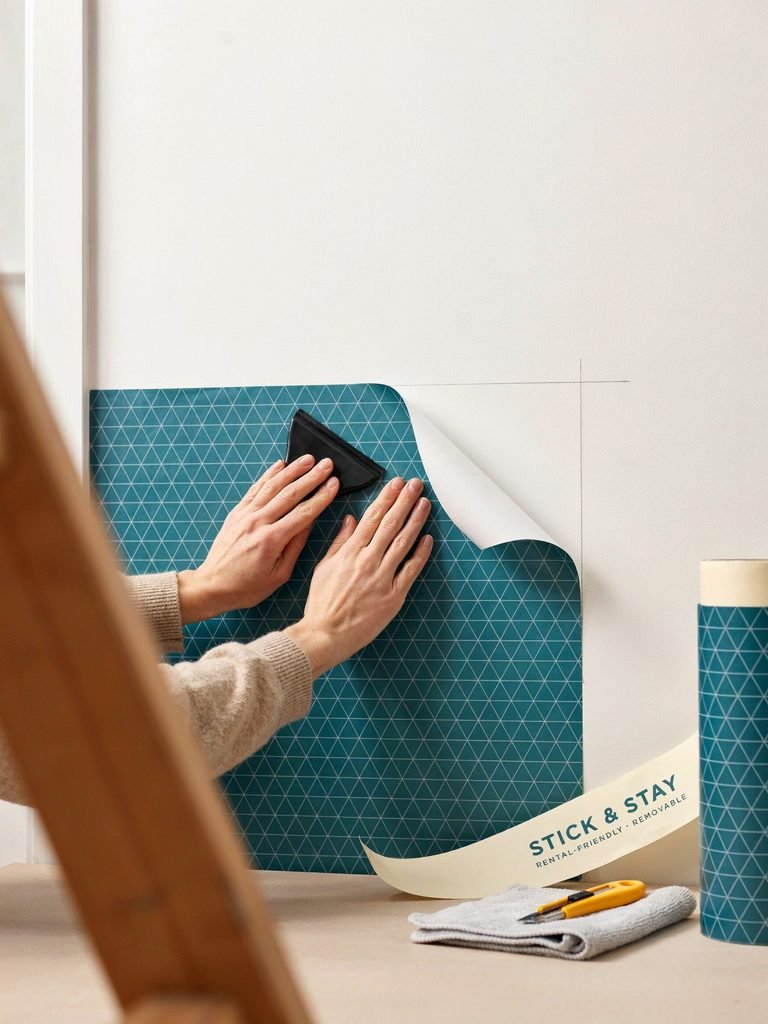 Hands Applying Wallpaper with a Squeegee